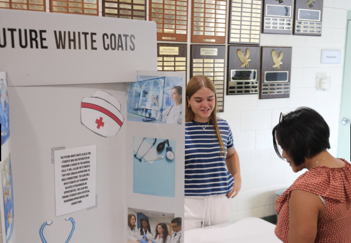 Upper School Director Mrs. Conn reviews the Future White Coats club poster